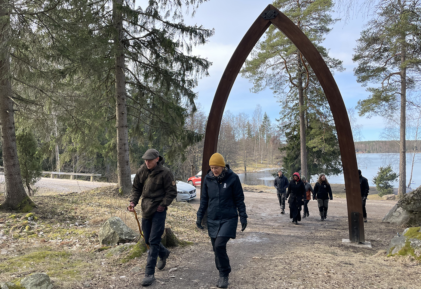 Bild på landshöving Maria Larsson i sällskap av guide vandrar genom porten till Fasaskogen.